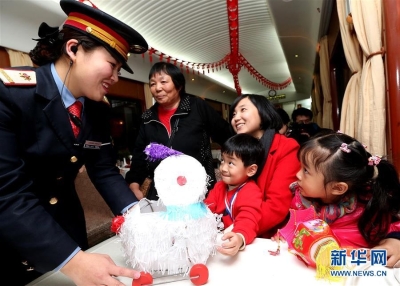  2月21日，在上海至九龙Z99次列车上，列车长陈杨云（左一）为香港小朋友郭子莹（右一）送上元宵节玩具“兔子灯”。